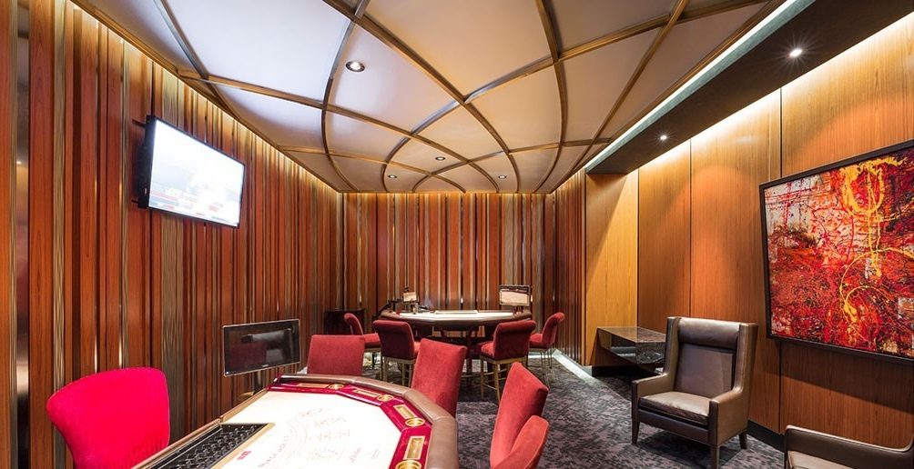 Un salon de jeu privé du Casino de Montréal : lames de bois verticales du plancher au plafond, arcs au plafond, fauteuils rouges