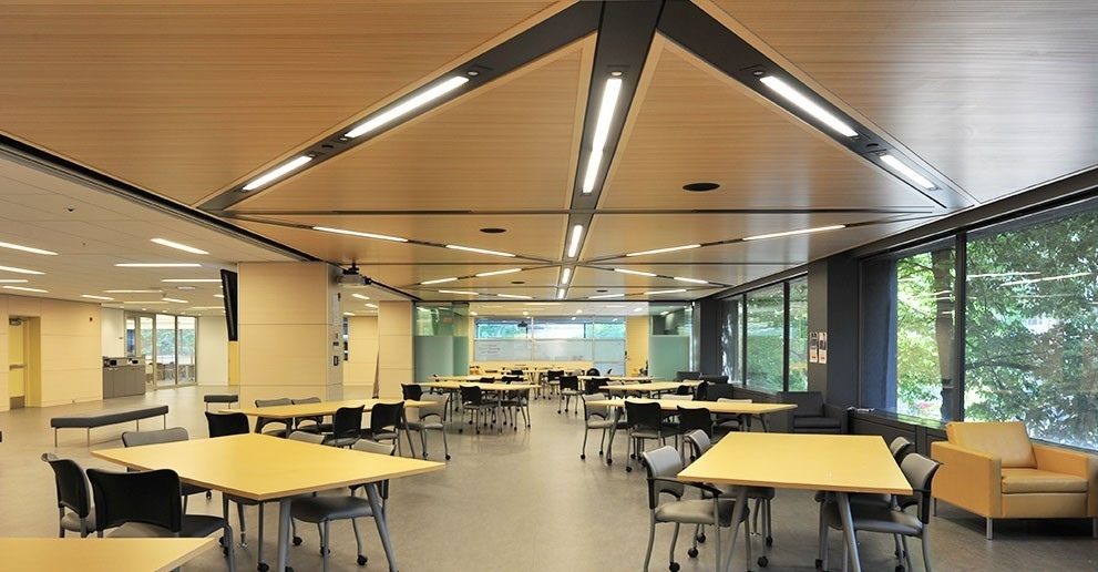 Une salle d’étude de l’Université McGill : plafond de bois à caissons triangulaires, luminaires encastrés, tables claires